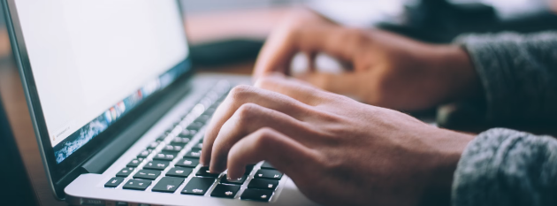 person typing onto laptop