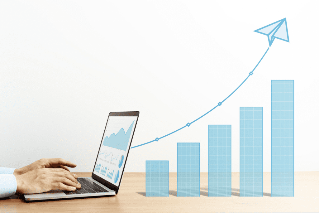 A laptop is positioned to the left of a bar graph with a gradual upward trajectory.