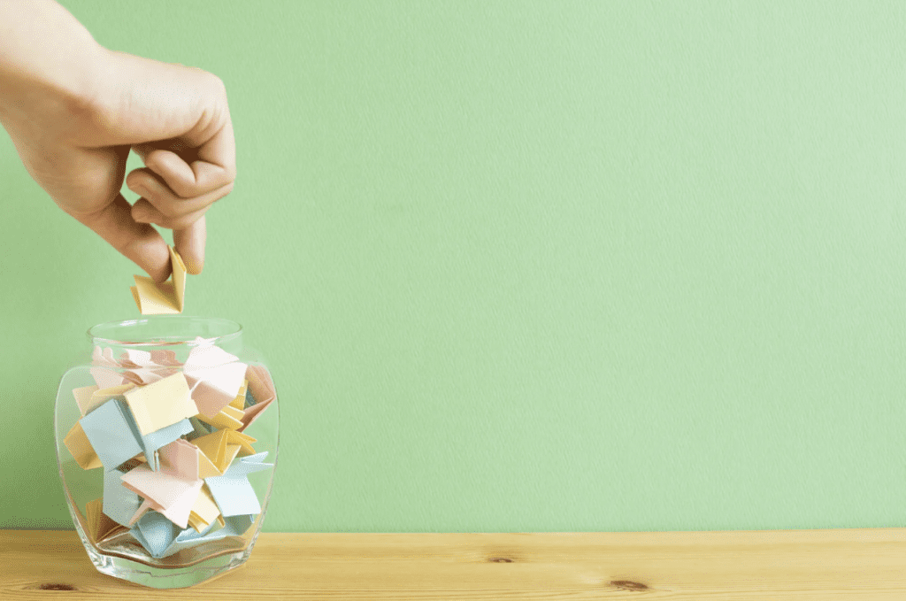An image of a hand picking a piece of paper out of a jar signifies randomization as an A/B testing best practice.