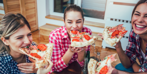 Attendees eating pizza at event venue