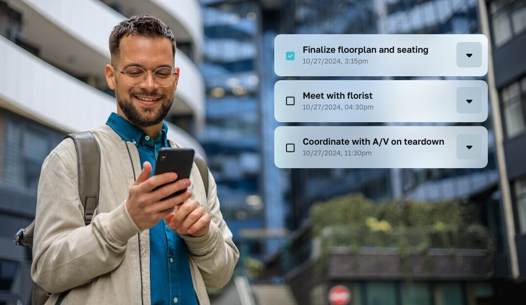 Man wearing glasses, smiling and looking at his mobile